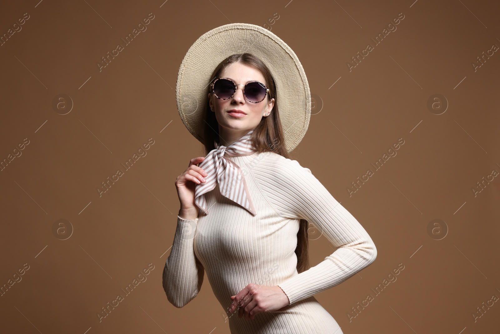 Fashionable portrait of beautiful woman in stylish outfit on brown background Photo of Fashionable portrait of beautiful woman in stylish outfit on brown background