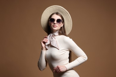 Photo of Fashionable portrait of beautiful woman in stylish outfit on brown background
