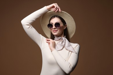 Photo of Fashionable portrait of beautiful woman in stylish outfit on brown background
