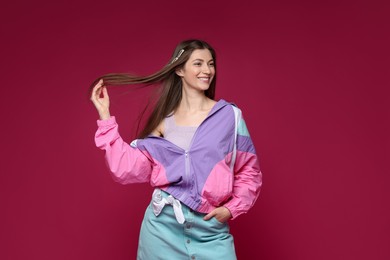 Photo of Fashionable portrait of beautiful woman in stylish outfit on crimson background