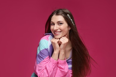 Photo of Fashionable portrait of beautiful woman in stylish outfit on crimson background