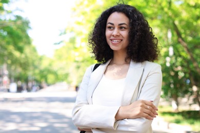 Photo of Portrait of smiling Latin American woman outdoors. Space for text