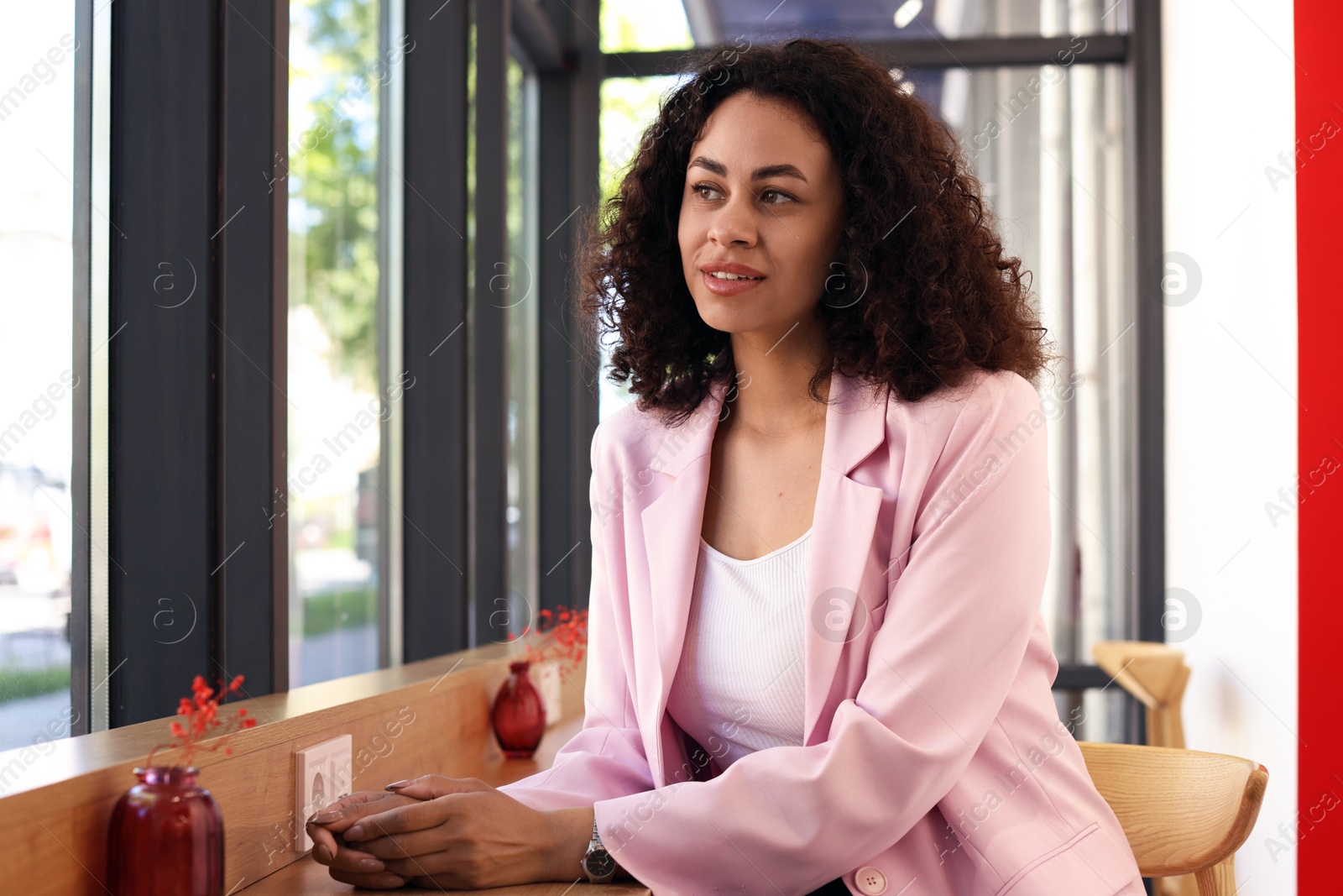 Smiling Latin American woman sitting in cafe Photo of Smiling Latin American woman sitting in cafe