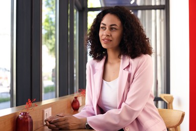 Photo of Smiling Latin American woman sitting in cafe