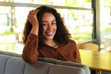 Photo of Portrait of smiling Latin American woman in cafe