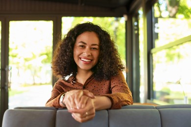 Photo of Portrait of smiling Latin American woman in cafe