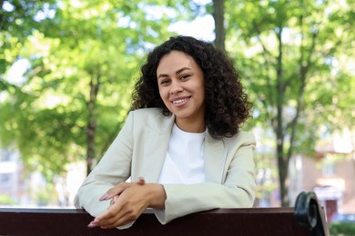 Photo of Portrait of smiling Latin American woman on bench outdoors