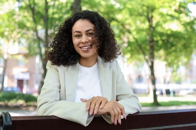 Photo of Portrait of smiling Latin American woman on bench outdoors