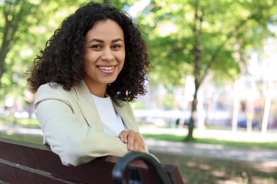 Photo of Portrait of smiling Latin American woman on bench outdoors