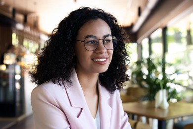 Photo of Portrait of smiling Latin American woman in cafe