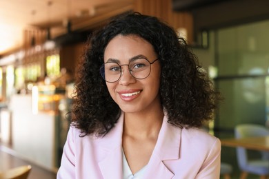 Photo of Portrait of smiling Latin American woman in cafe