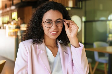 Photo of Portrait of smiling Latin American woman in cafe