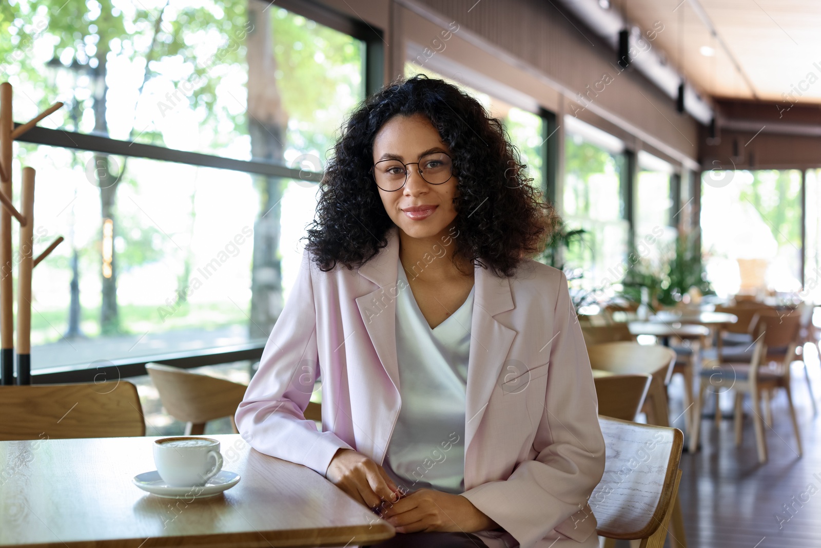 Portrait of beautiful Latin American woman at table in cafe Photo of Portrait of beautiful Latin American woman at table in cafe