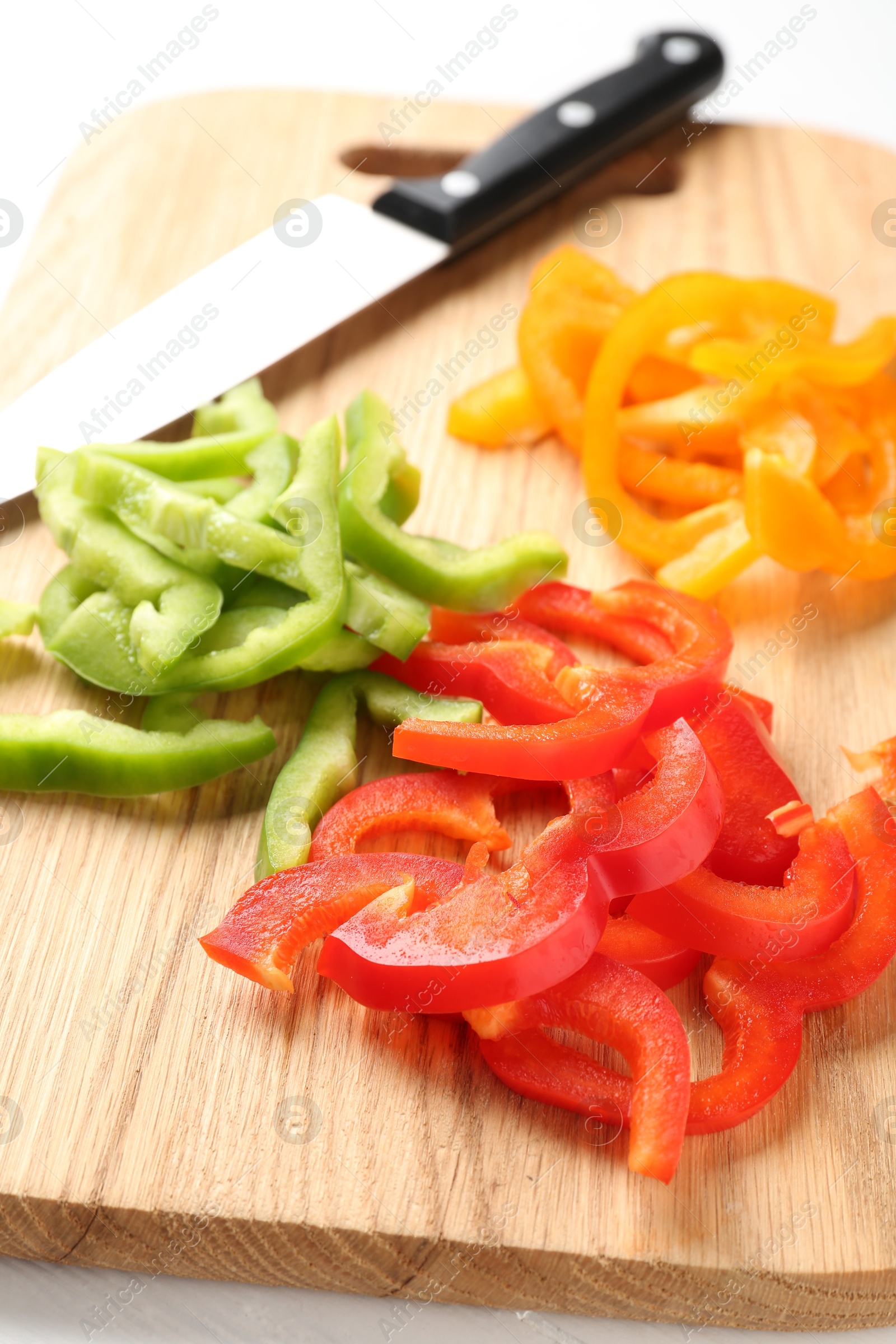 Photo of Slices of fresh colorful bell peppers on white table, closeup