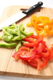 Photo of Slices of fresh colorful bell peppers on white table, closeup