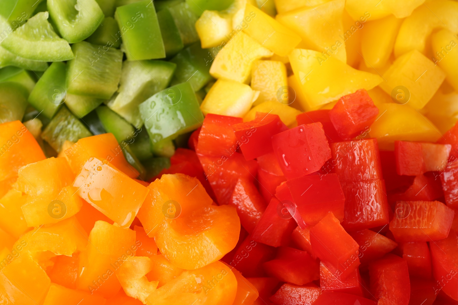Pieces of fresh colorful bell peppers with water drops as background, above view Photo of Pieces of fresh colorful bell peppers with water drops as background, above view
