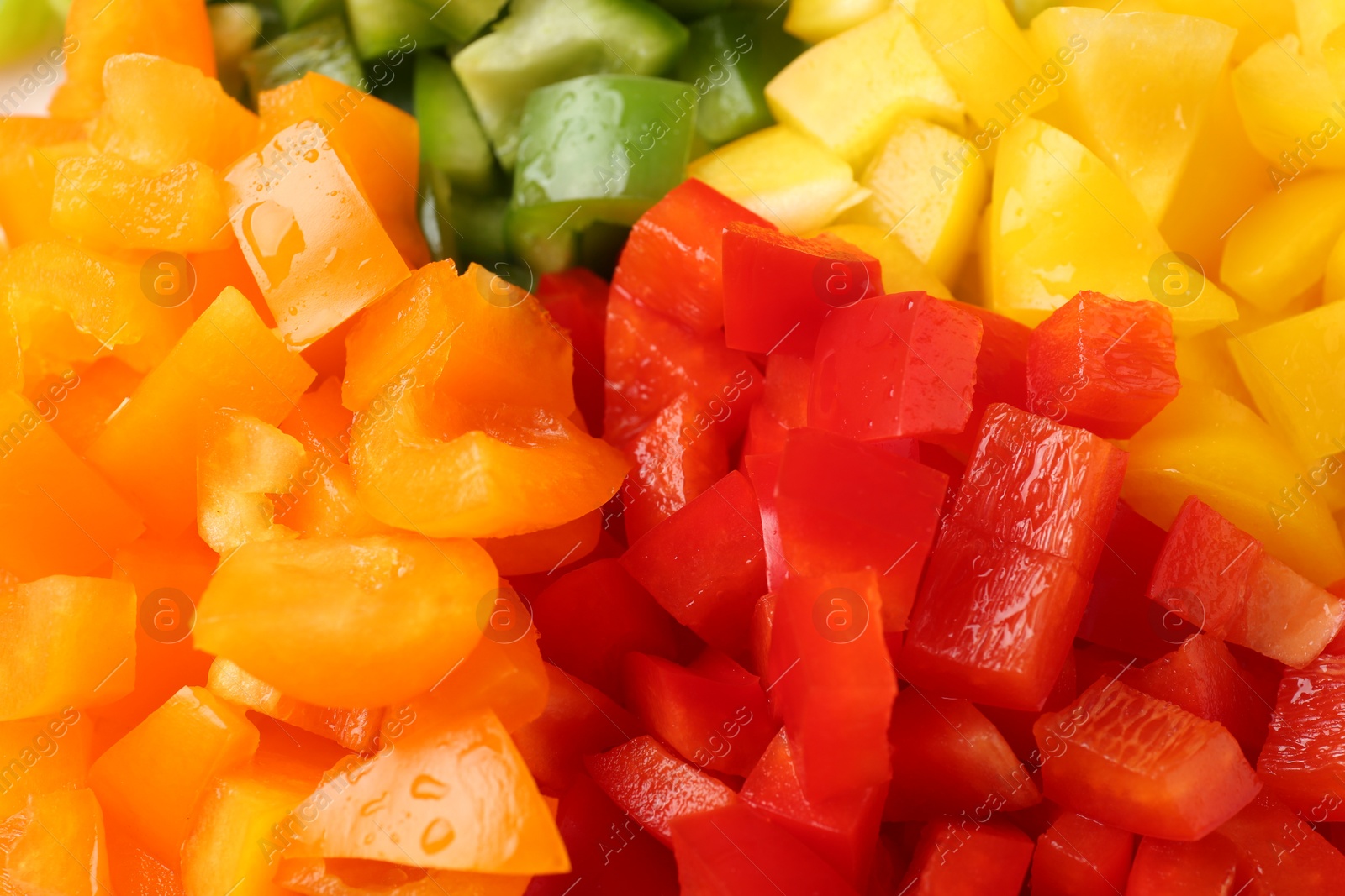 Photo of Pieces of fresh colorful bell peppers with water drops as background, closeup