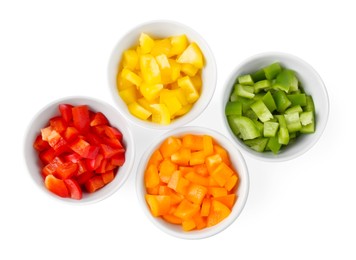 Photo of Pieces of fresh colorful bell peppers in bowls isolated on white, top view