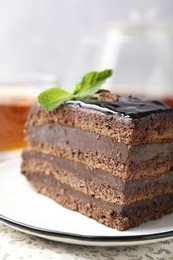 Photo of Piece of chocolate cake served with mint on table, closeup