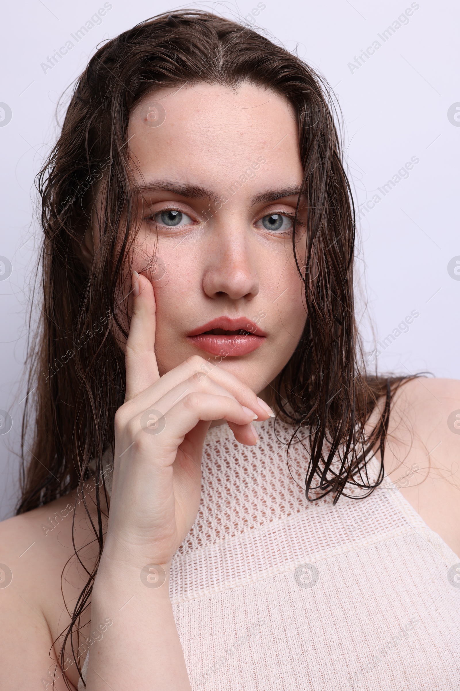 Portrait of beautiful woman with natural skin complexion on light grey background, closeup Photo of Portrait of beautiful woman with natural skin complexion on light grey background, closeup