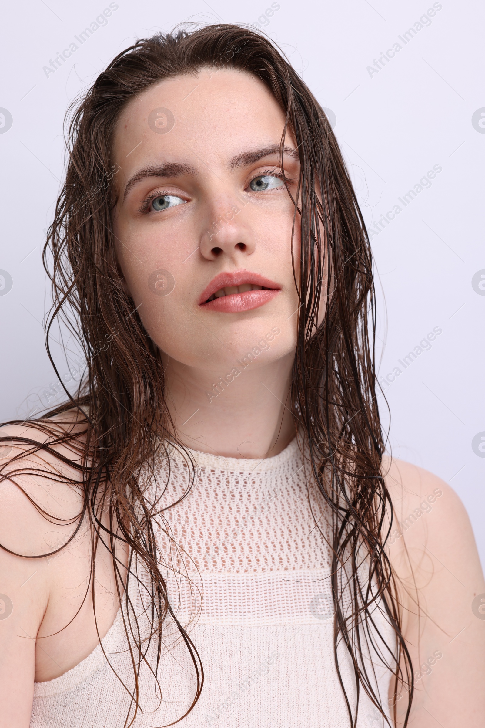 Portrait of beautiful woman with natural skin complexion on light grey background, closeup Photo of Portrait of beautiful woman with natural skin complexion on light grey background, closeup