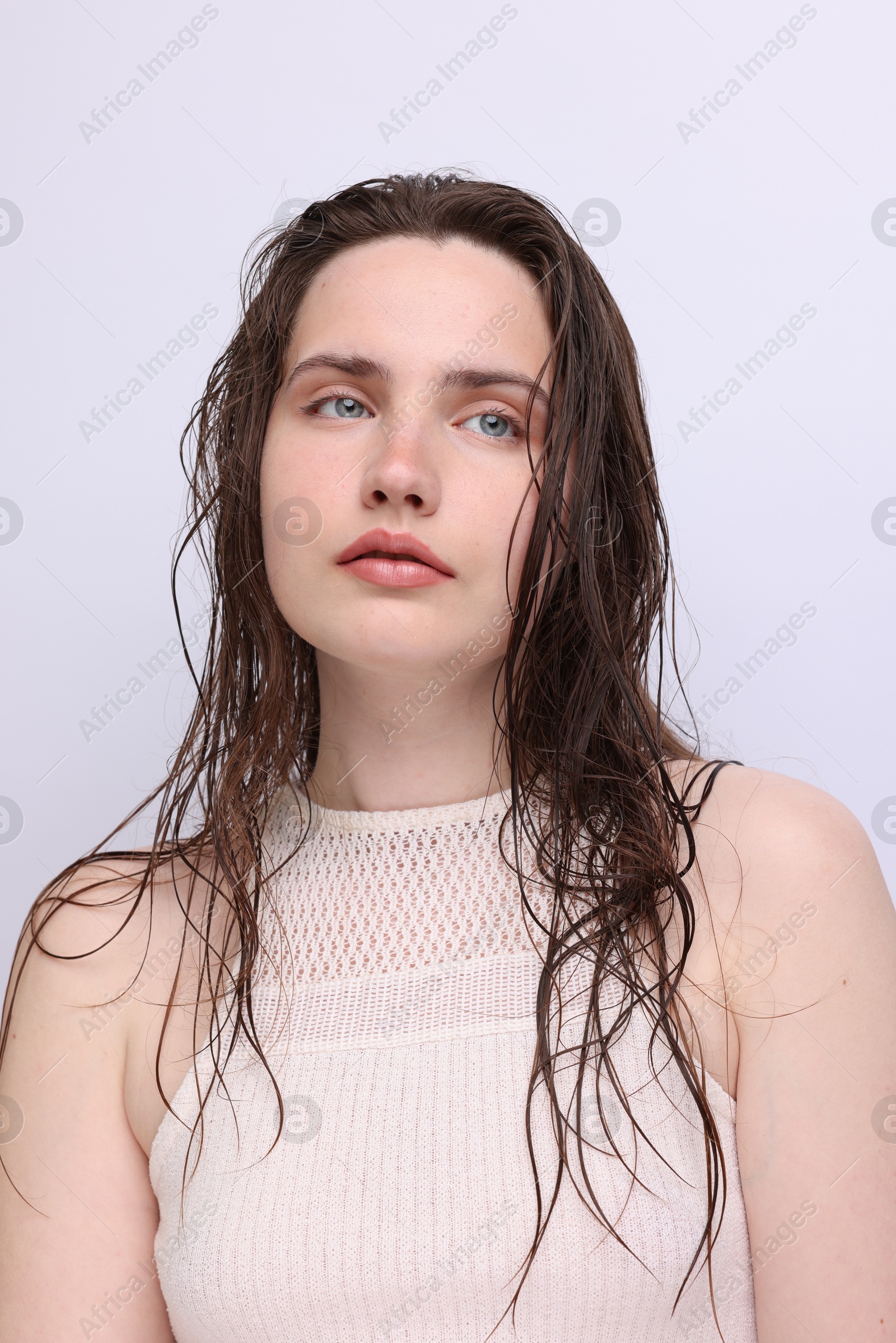 Portrait of beautiful woman with natural skin complexion on light grey background, closeup Photo of Portrait of beautiful woman with natural skin complexion on light grey background, closeup