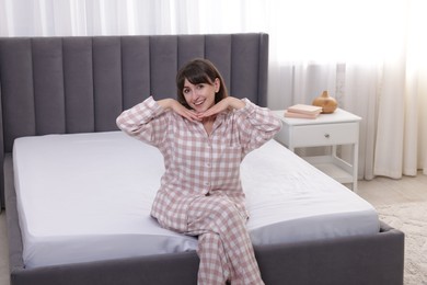 Photo of Beautiful woman sitting on soft mattress at home