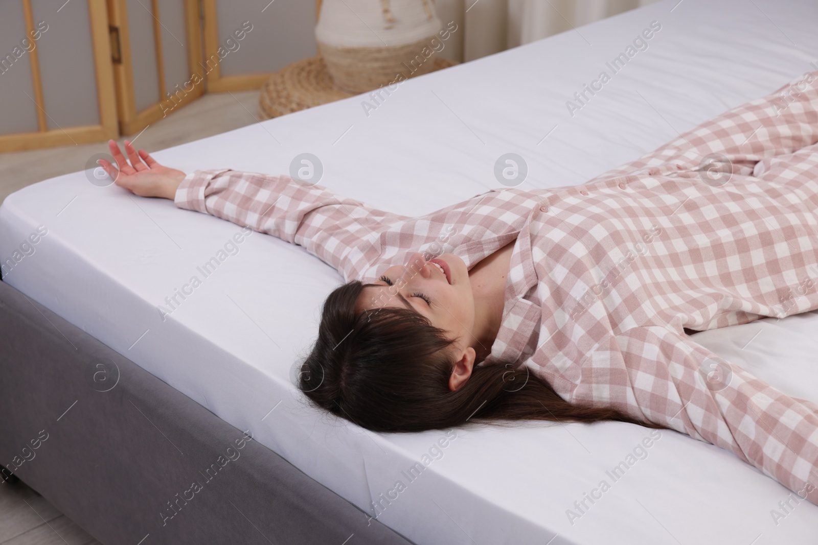 Beautiful woman lying on soft mattress at home Photo of Beautiful woman lying on soft mattress at home