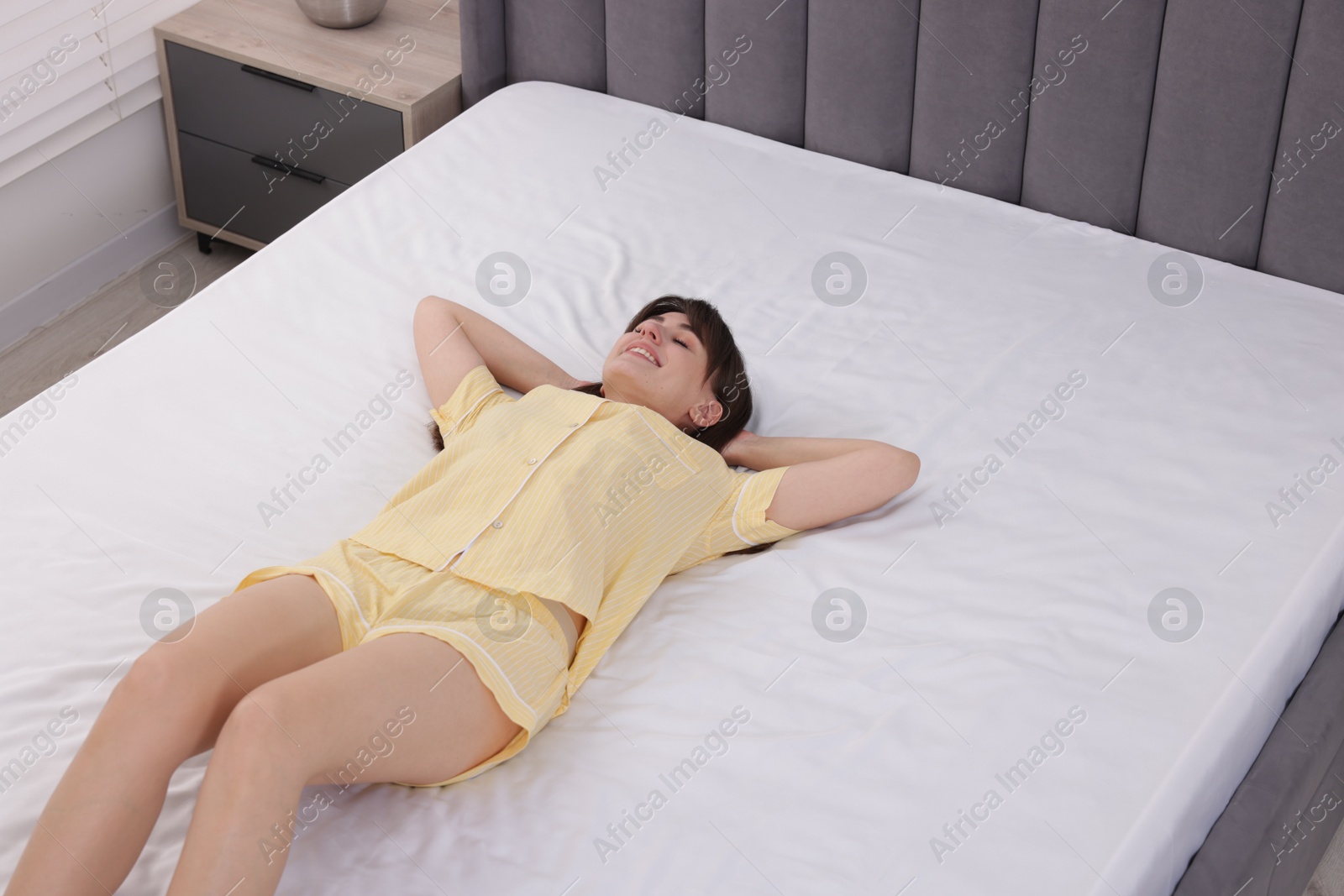 Beautiful woman lying on soft mattress at home Photo of Beautiful woman lying on soft mattress at home
