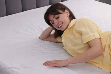 Photo of Beautiful woman lying on soft mattress at home