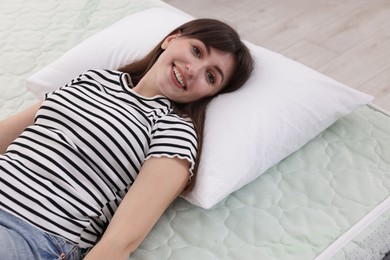 Photo of Beautiful woman lying on soft mattress at home