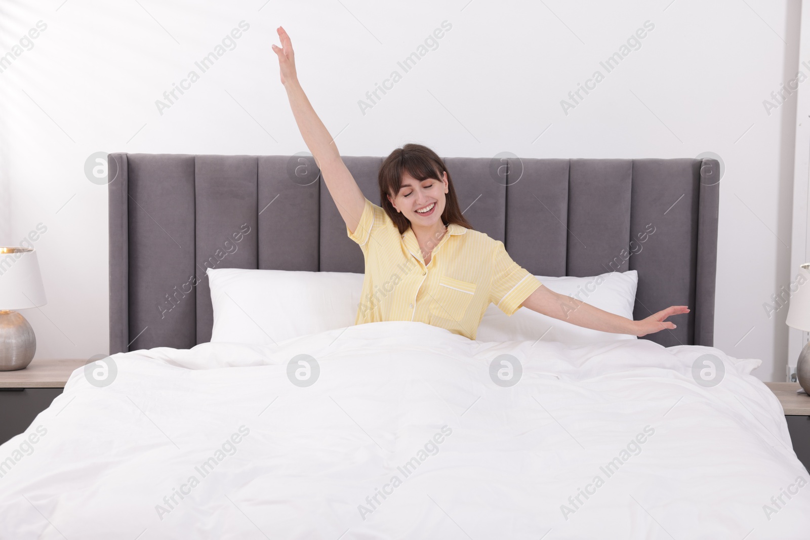 Beautiful woman awaking in comfortable bed at home Photo of Beautiful woman awaking in comfortable bed at home