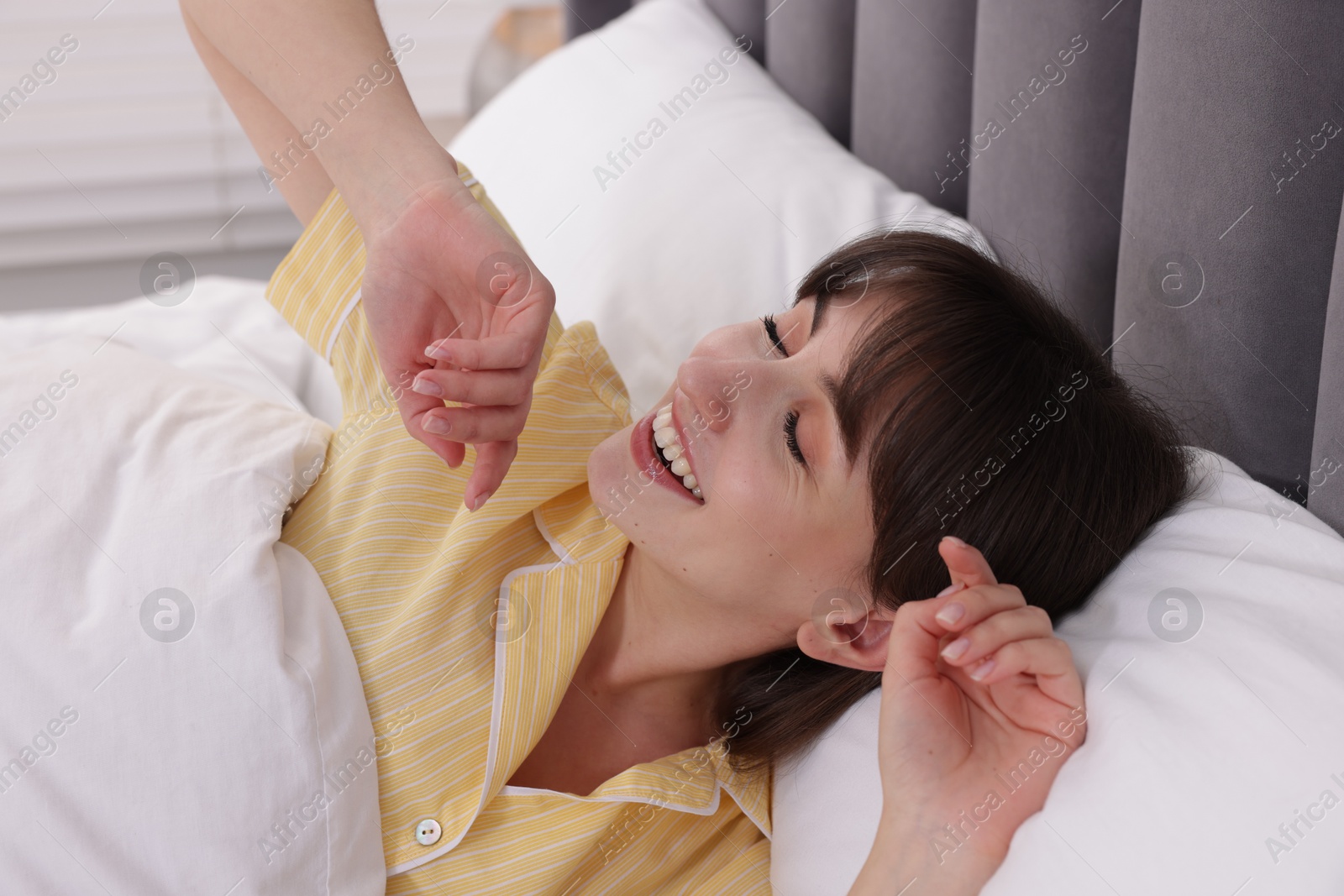 Sleepy woman yawning in bed at home Photo of Sleepy woman yawning in bed at home