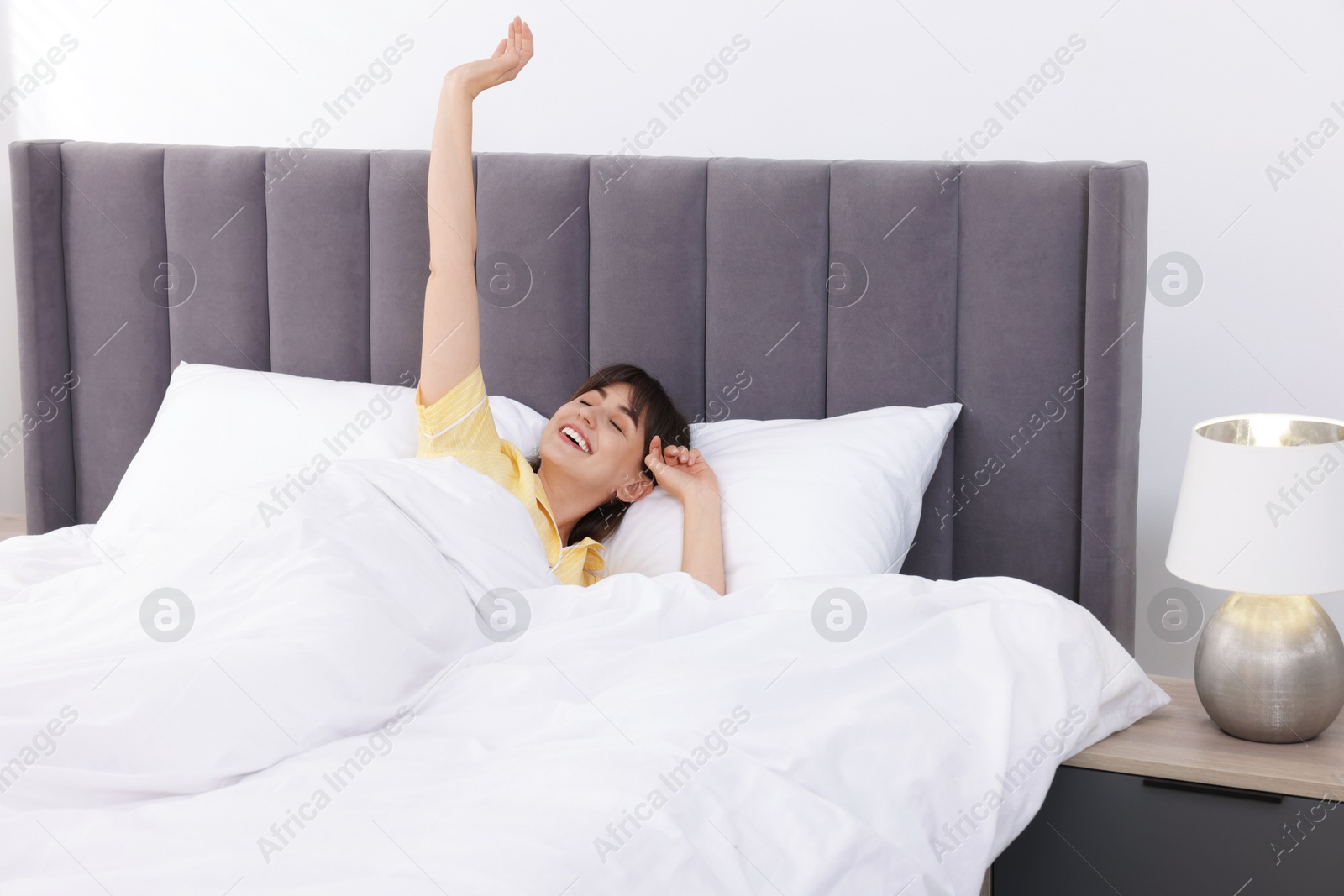 Beautiful woman awaking in comfortable bed at home Photo of Beautiful woman awaking in comfortable bed at home