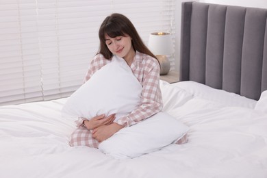 Photo of Beautiful woman with pillow on bed at home