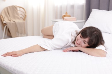 Photo of Beautiful woman lying on soft mattress at home
