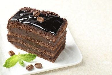 Photo of Piece of chocolate cake served with mint on white table, closeup. Space for text