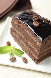 Photo of Piece of chocolate cake served with mint on white table, closeup