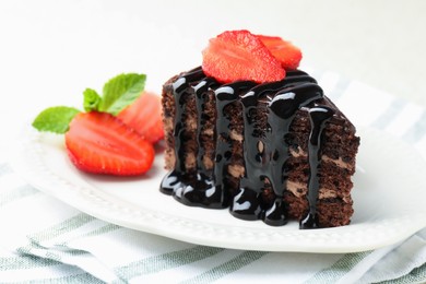 Photo of Piece of chocolate cake served with strawberries on table, closeup