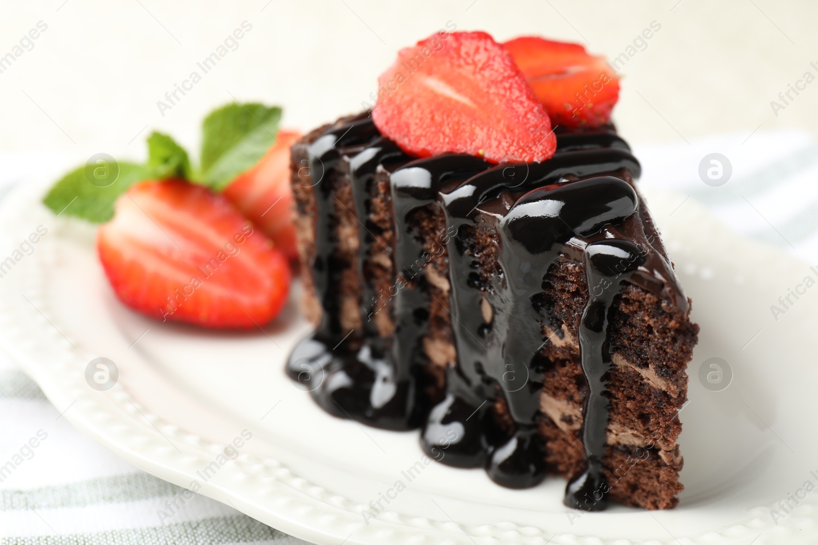 Photo of Piece of chocolate cake served with strawberries on table, closeup