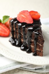 Photo of Piece of chocolate cake served with strawberries on table, closeup