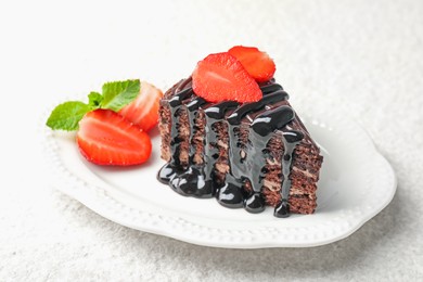 Photo of Piece of chocolate cake served with strawberries on white table, closeup