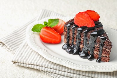 Photo of Piece of chocolate cake served with strawberries on white table, closeup