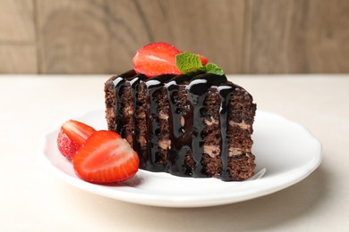 Photo of Piece of chocolate cake served with strawberries on white table, closeup