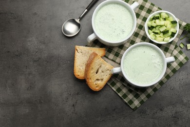 Photo of Tasty cucumber soup served on grey table, flat lay. Space for text