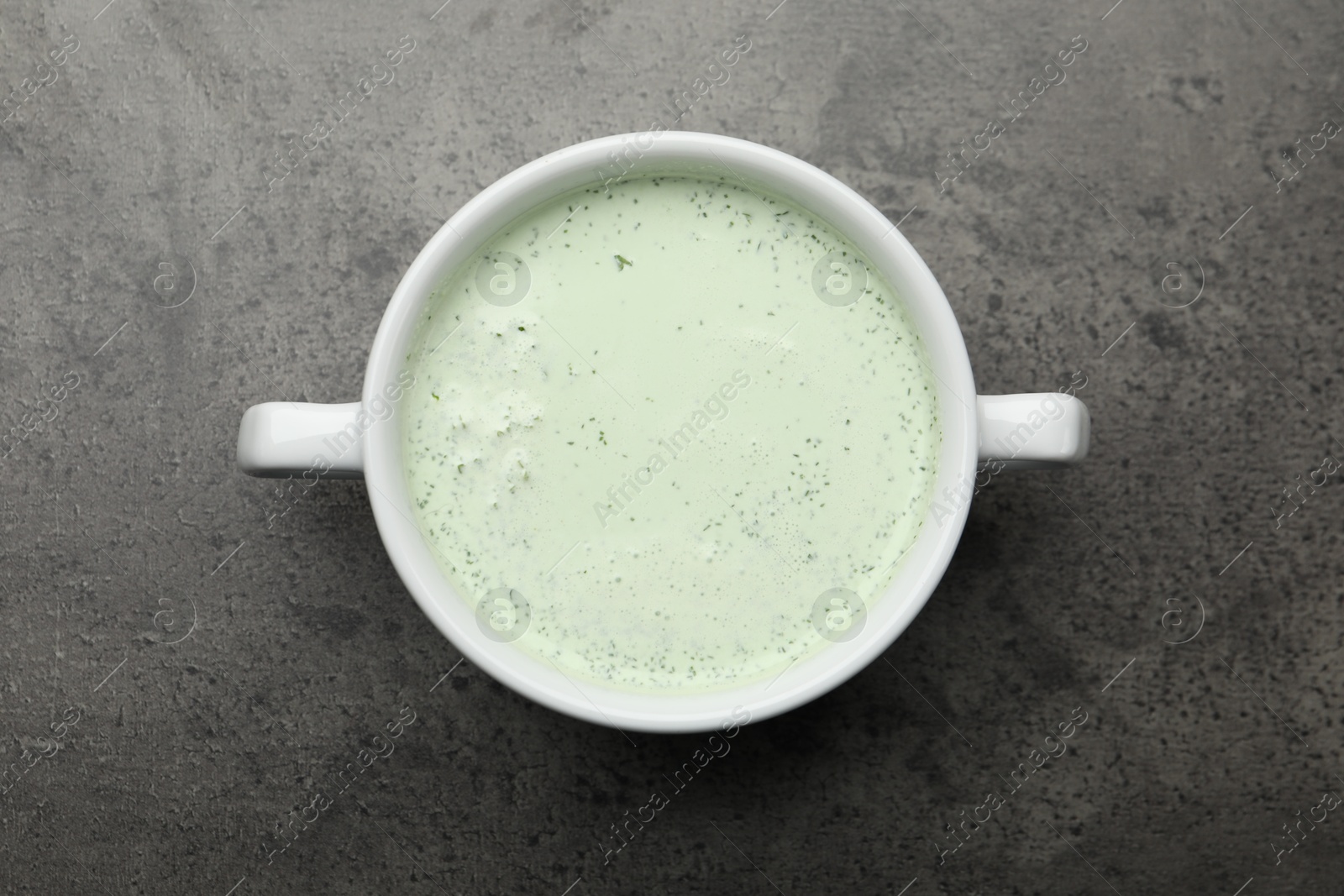 Photo of Tasty cucumber soup on grey table, top view