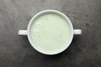 Photo of Tasty cucumber soup on grey table, top view