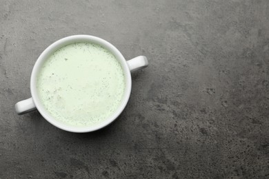 Photo of Tasty cucumber soup on grey table, top view. Space for text
