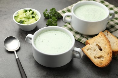 Photo of Tasty cucumber soup served on grey table, closeup