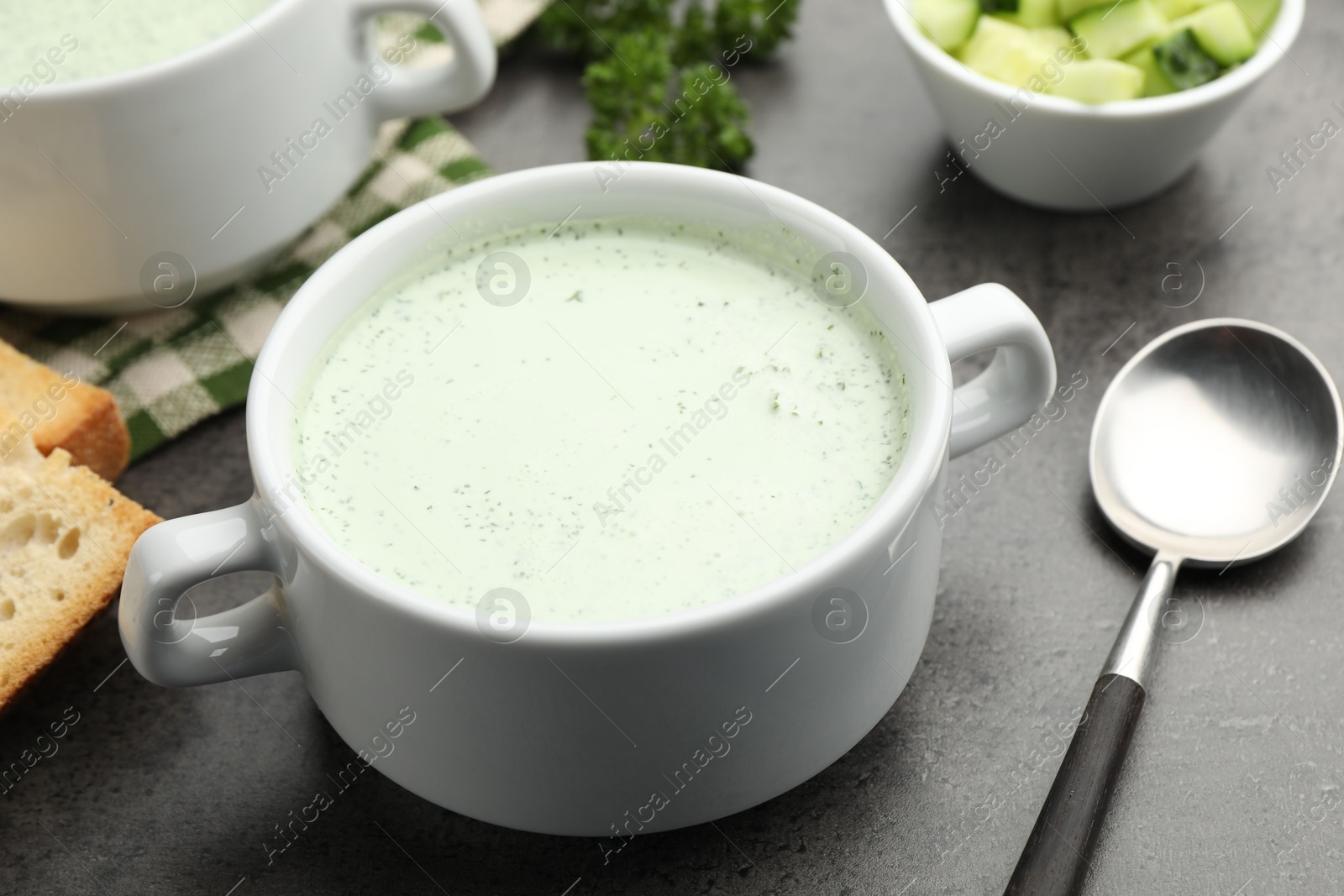 Photo of Tasty cucumber soup served on grey table, closeup